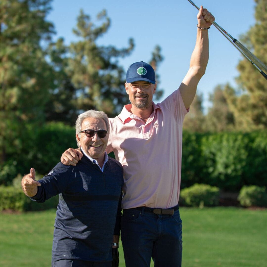 A man and woman holding onto a golf club